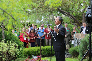 A Man in a Suit Speaking to a Crowd of People