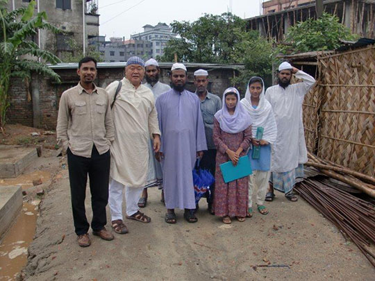 With teachers in front of boy’s school construction site