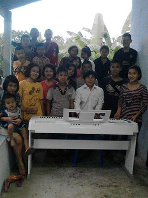 Pastor Bilay and the Bilay House children pose proudly with the new organ